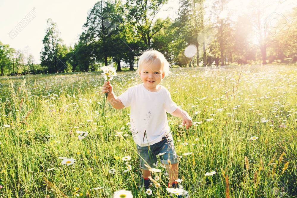 Happy child running on meadow of flowers