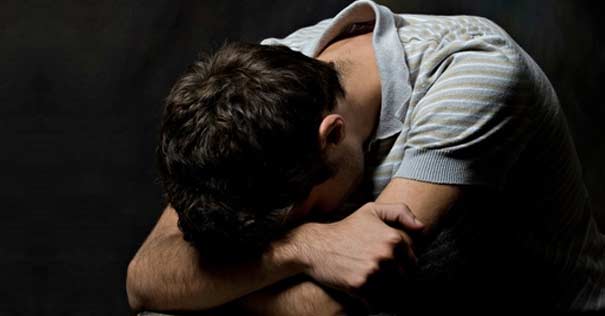 joven-cabeza-abajo-en-rodillas-triste-fondo-oscuro-270716