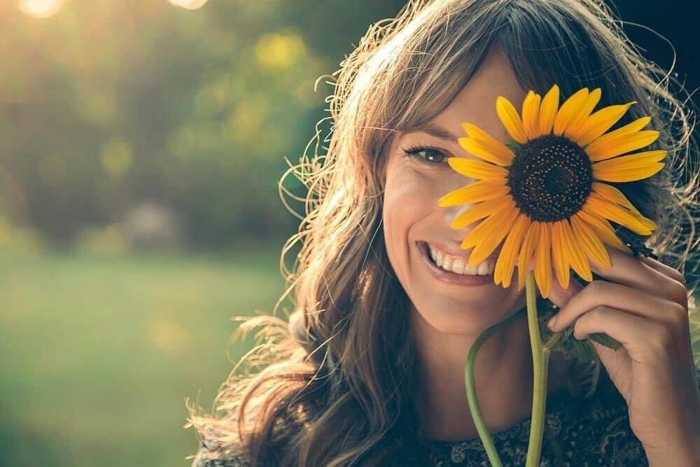 mujer-con-girasol-tapandole-el-rostro