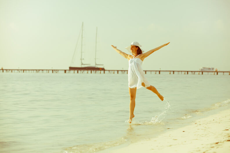 Caucasian woman dancing at the sea